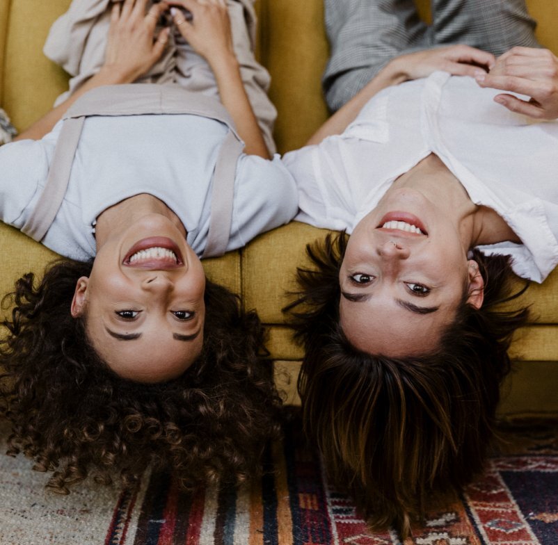 Two females laying on their back and smiling about their new home they bought